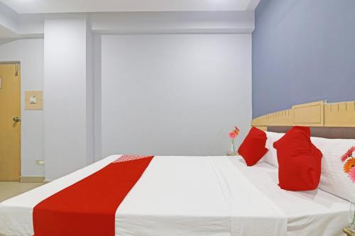a bedroom with a large bed with red pillows at Hotel O Padmini Near Lakdikapool Metro Station in Hyderabad
