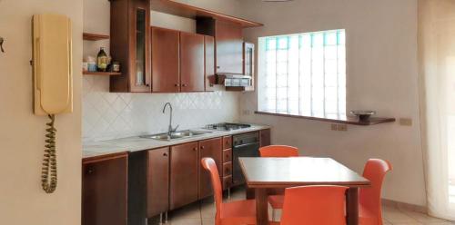 een keuken met een tafel en stoelen en een tafel en een wastafel bij Comfortable apartment in Marsala with balcony and parking in Marsala
