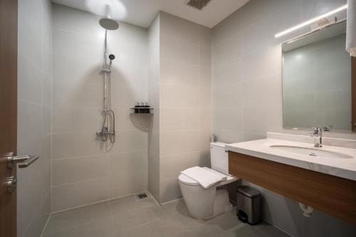 a bathroom with a sink and a toilet and a mirror at The HUB Hotel - Airport in Ho Chi Minh City