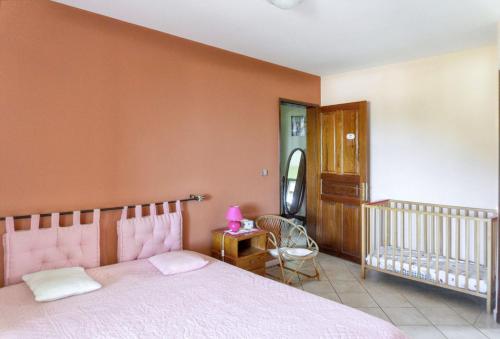 a bedroom with a pink bed and a crib at Superbe appartement à Petite Île avec vue mer et montagne. in Petite Île