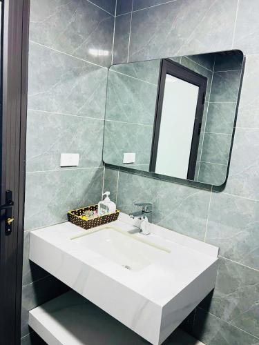 a bathroom with a white sink and a mirror at Sapa Grand Blue Hotel in Sa Pa