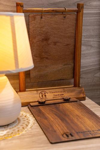 a table with a lamp and a sign on a table at Hanhhome in Ho Chi Minh City