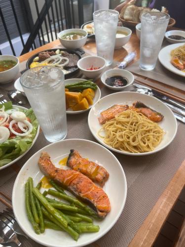 a table topped with plates of food and pasta at Hanhhome in Ho Chi Minh City