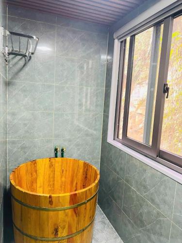 a wooden tub in a bathroom with a window at Sapa Grand Blue Hotel in Sa Pa
