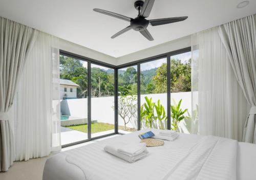 a bedroom with a white bed and a large window at Villa Amour 3 Bedroom Spa Pool Retreat near Beach - Lamai in Amphoe Koh Samui