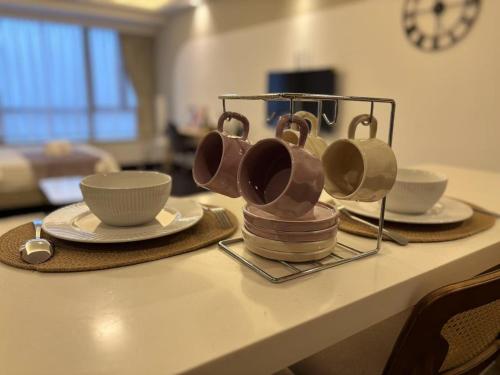 a table with cups and saucers on top of it at TheBess Hotel Tokyo is located adjacent to Singapore and offers a sea viewIt is a family business smart room with the sea view of Princess Bay富力公主湾 in Johor Bahru