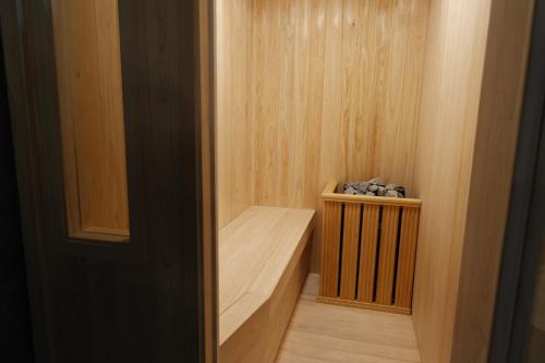 a small sauna with a wooden bench in a room at Bluedot Poshtel in Seoul