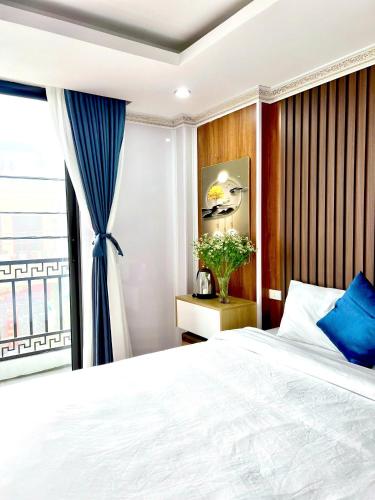 a bedroom with a large bed and a window at Sapa Grand Blue Hotel in Sa Pa