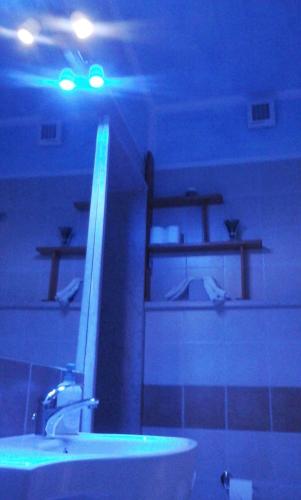 a bathroom with a sink and a blue light at La Casa di Ulisse B&B in Quercianella