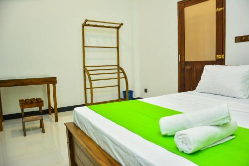 a bedroom with a bed with green sheets and a ladder at Ocean Bliss Villa Mirissa in Kamburugamuwa
