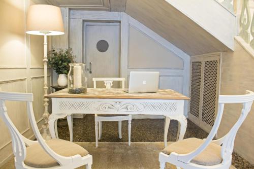 a white desk with two chairs and a laptop on it at Ares Hotel in Zamora