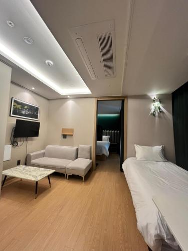 a hotel room with a bed and a couch at Haeundae Lamer Stay in Busan