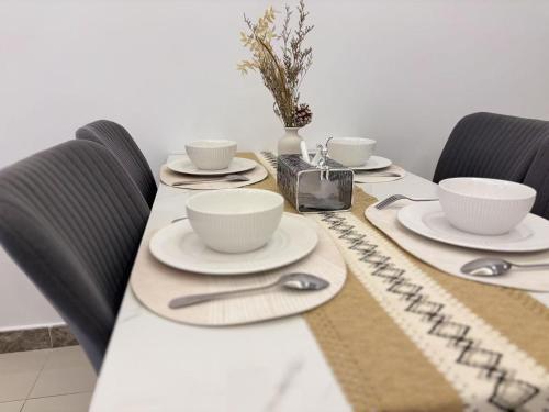 a table with two cups and saucers on it at TheBess Hotel Tokyo is located adjacent to Singapore and offers a sea viewIt is a family business smart room with the sea view of Princess Bay富力公主湾 in Johor Bahru