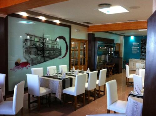 a dining room with a table and white chairs at El Torreon del Miguelete in Miguel Esteban