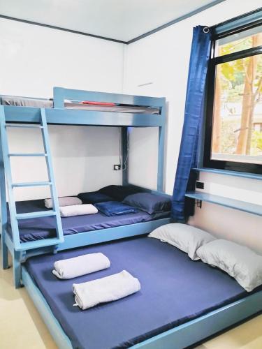 a room with two bunk beds and a ladder at Full House in El Nido