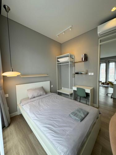 Un dormitorio con una gran cama blanca y un escritorio. en Lioravilla15 with warmpool KBP near WHOOSH and WAHOO, en Padalarang