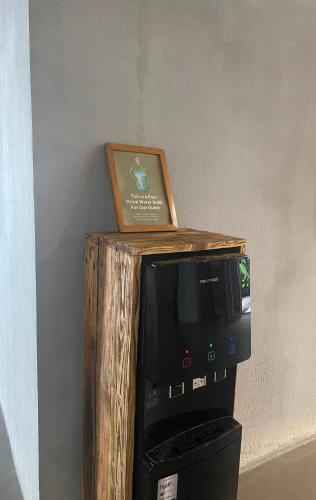 a microwave sitting on top of a wooden stand with a picture at Greenhost Boutique Hotel Prawirotaman in Yogyakarta