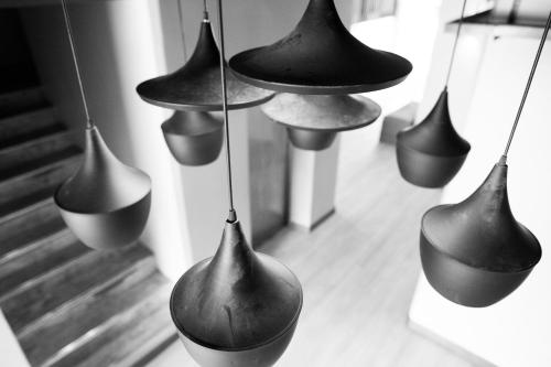 a group of black vases hanging from a wall at KENCOZY accommodation in Bangkok