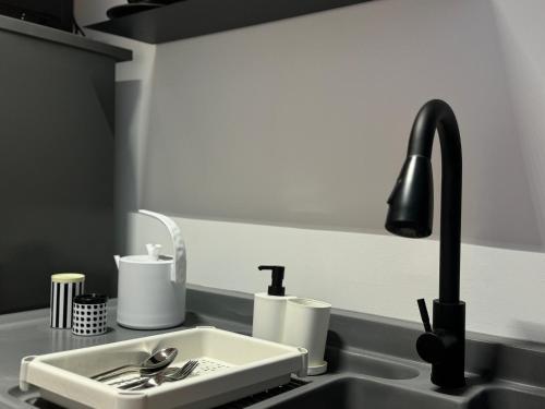 a kitchen sink with a black faucet at X - The Subiaco - Edumetro Subang Jaya in Subang Jaya