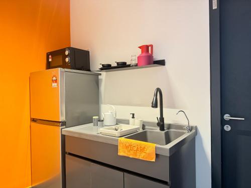 a kitchen with a sink and a refrigerator at X - The Subiaco - Edumetro Subang Jaya in Subang Jaya