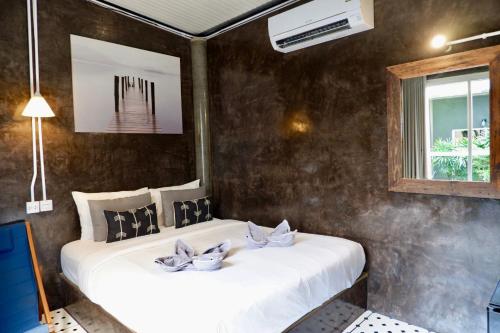 ein Schlafzimmer mit zwei Betten und einem Fenster in der Unterkunft แอทเกาะล้านรีสอร์ท in Ko Sak