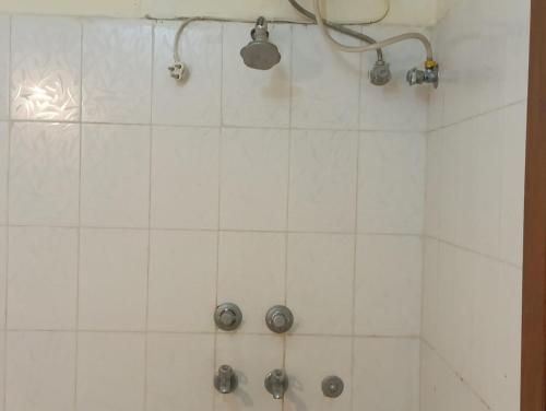 a bathroom with a shower with white tiles at Nature Care Home stay in Chandīgarh