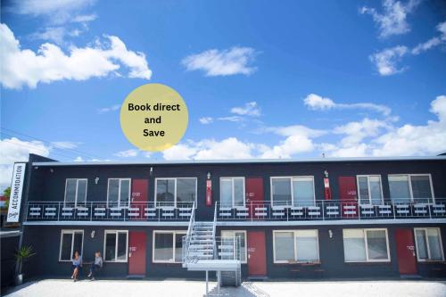 a building with a sign that reads book direct and save at Siesta Central Apartments in Sale