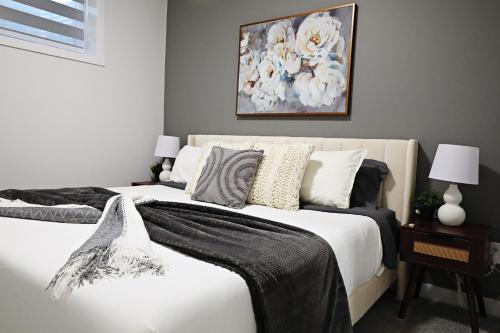 ein Schlafzimmer mit zwei Betten und einem Gemälde an der Wand in der Unterkunft Beautiful Suite King Bed,Long Stays,Disney,Airport in Edmonton