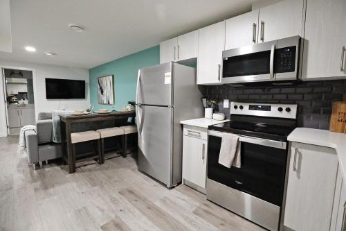 a kitchen with a stainless steel refrigerator and a table at Beautiful Suite King Bed,Long Stays,Disney,Airport in Edmonton