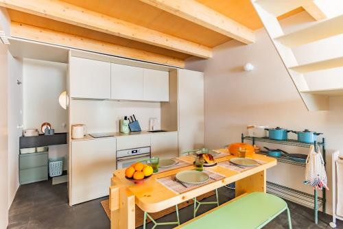 a kitchen with a wooden table and green chairs at Urban Pop Loft at Alfama in Lisbon