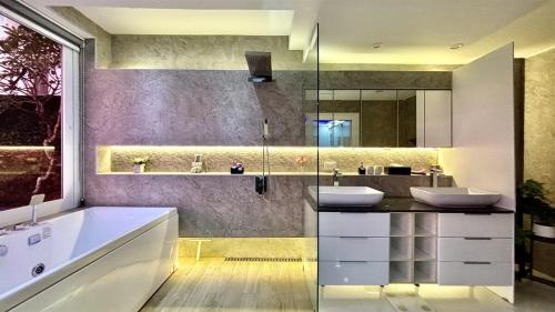 a bathroom with two sinks and a large mirror at Sawansa 33A 400m2 Luxury Seaview Pool near Beach in Patong Beach