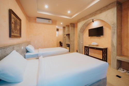 a hotel room with two beds and a tv at Bella Tuscany's home in Nong Sarai