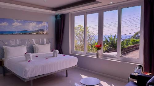 a bedroom with a large white bed and large windows at Sawansa 33B 425m2 Luxury Seaview Pool near Beach in Patong Beach