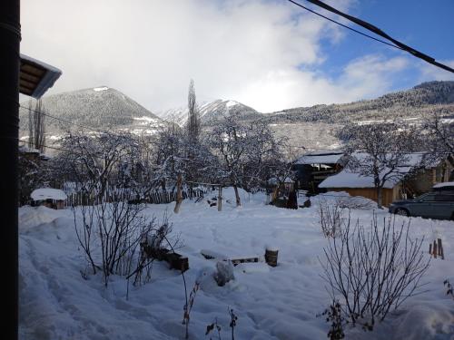 a yard covered in snow with mountains in the background at Mishgu Qor in Mestia