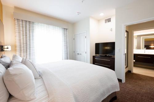 a bedroom with a white bed and a television at Residence Inn by Marriott Oklahoma City North/Quail Springs in Oklahoma City