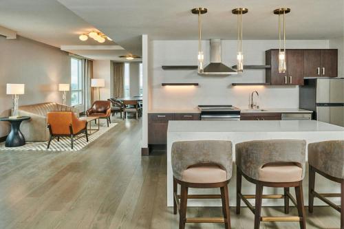 a kitchen and living room with a counter and chairs at Residence Inn By Marriott Berkeley in Berkeley