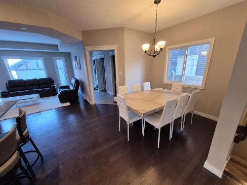 a dining room and living room with a table and chairs at Sean Comfy Home in Edmonton