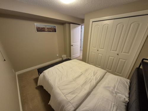 a bedroom with a white bed and a door at Sean Comfy Home in Edmonton