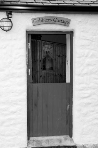 a door to a building with a sign above it at Cobblers Cottage Creggan in Greencastle