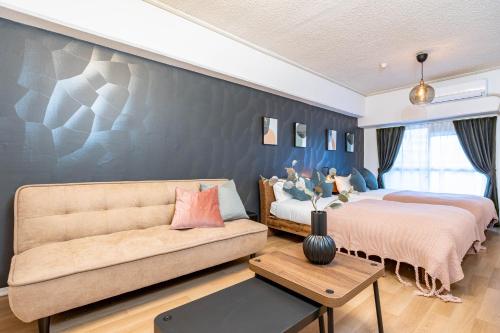 a bedroom with two beds and a couch at Lions Mansion Shin-Osaka in Osaka