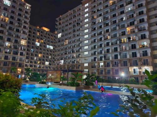 a large swimming pool in front of two large buildings at Saki Studio in Lapu Lapu City