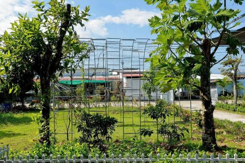 a metal fence in a garden with trees at BiXu House in Phu Quoc