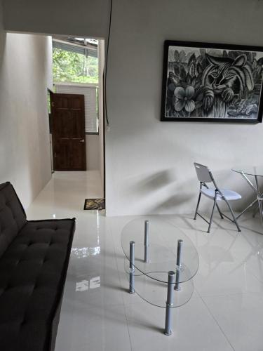 a living room with a glass table and a chair at Cool Waters Jungle Villas in Uvita