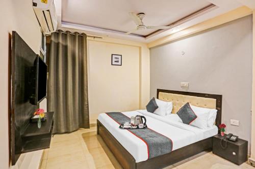 una habitación de hotel con una cama y un televisor en Townhouse Zodiac Near Botanic Garden of Indian Republic, en Noida