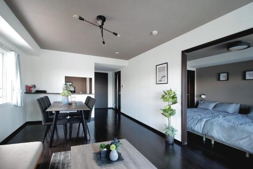 a living room with a bed and a table at Norwegian Wood 2 in Sapporo