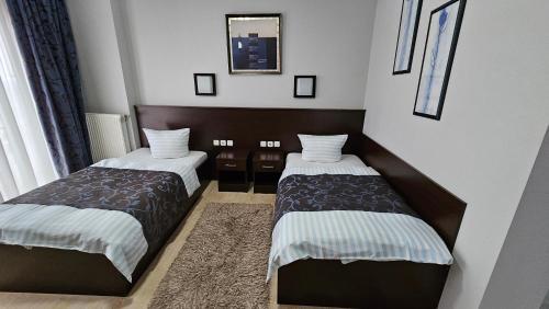 two beds in a small room with at Hotel Poarta Transilvaniei in Bistriţa