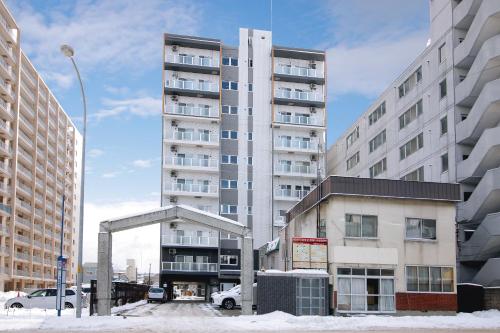 a tall apartment building in the middle of a city at Norwegian Wood 2 in Sapporo