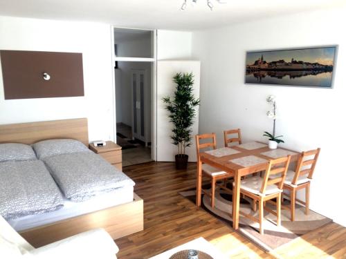 een slaapkamer met een bed en een tafel en stoelen bij Apartment Westside in Regensburg