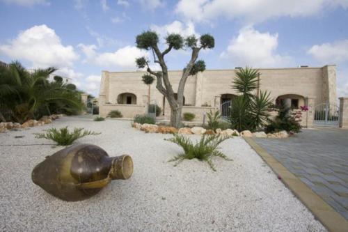 una bottiglia di vetro seduta a terra di fronte a un edificio di Oasi Del Visir Resort a San Vito dei Normanni