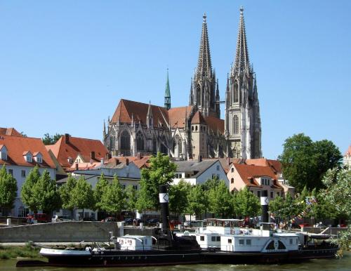 a city with a church and a river with boats at Apartment Westside in Regensburg
